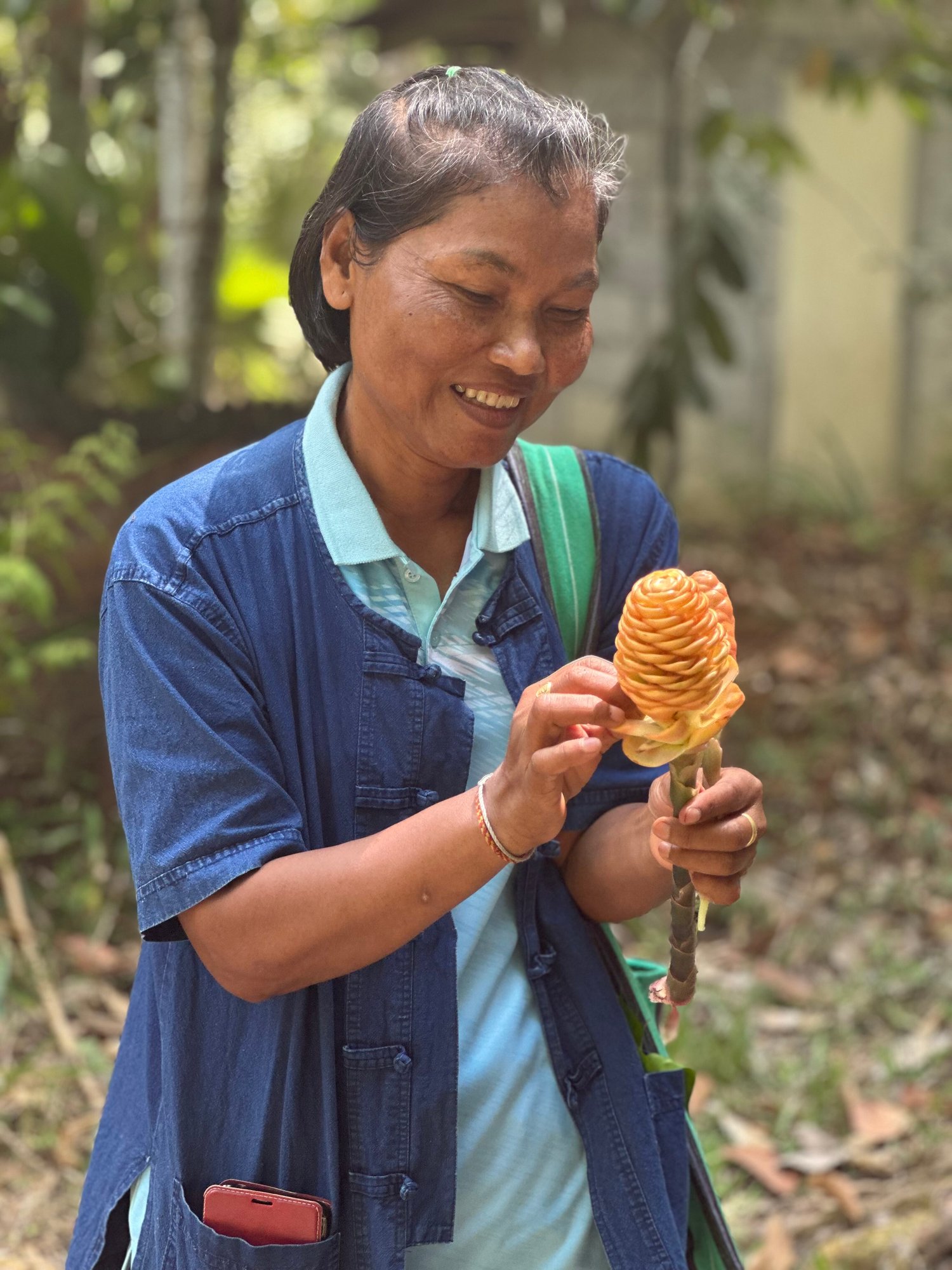 Natha Chaiphet (Ja) shows fire torch ginger, one of many secondary crops found in Wanakaset forest gardens.